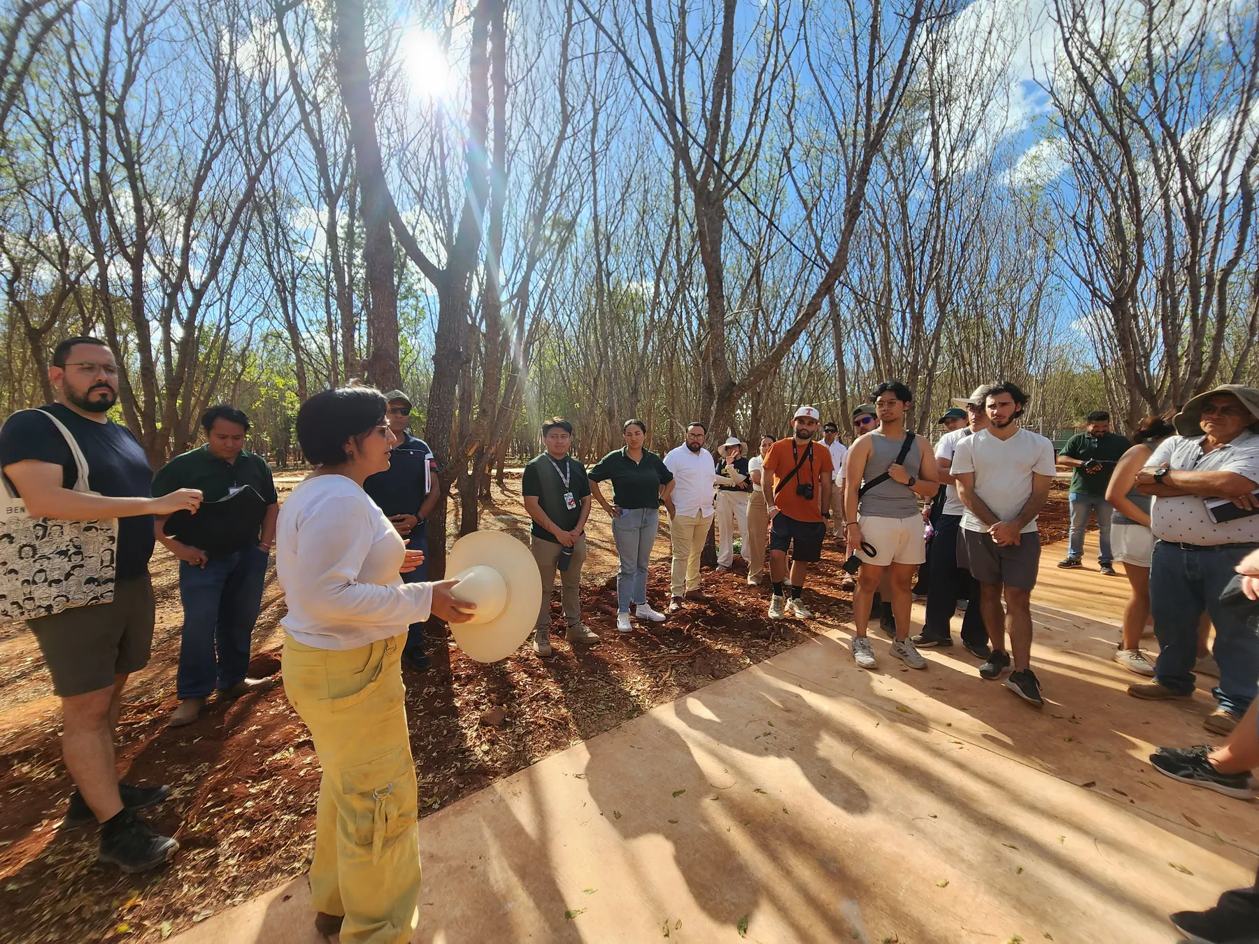 Bióloga explicando a un grupo de estudiantes el estado de la Unidad de Manejo para la Conservación de la Vida Silvestre, entre árboles.