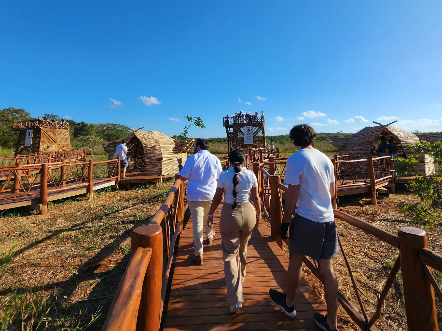 Estudiantes recorriendo una pasarela de madera en la zona 3 del Parque Nuevo Uxmal, aún en construcción.