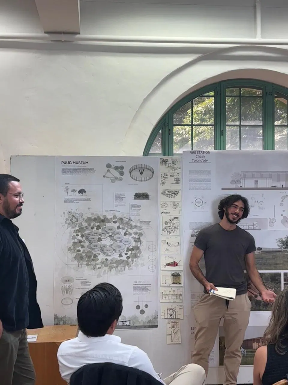 Segunda vista de la presentación en UT Austin, con los paneles del proyecto desplegados y el público sentado.
